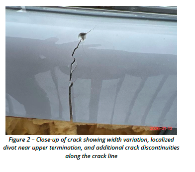Close-up of crack showing width variation and localized divot near upper termination